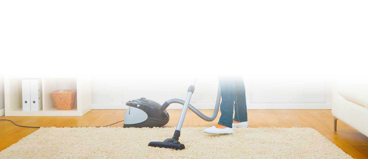 Lady vacuuming a rug